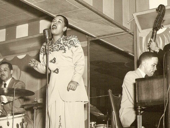 Billie Holiday performs live at Club Bali in Washington, D.C. (September 1948) alongside Al Dunn and Bobby Tucker—capturing the powerful, immediate stage presence that audiences celebrated while often disconnecting her music from the ongoing struggles of her daily life