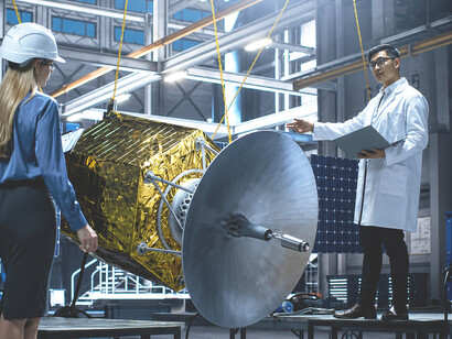A diverse team of aerospace engineers and scientists works on a satellite prototype, employing cutting-edge technology to advance space exploration