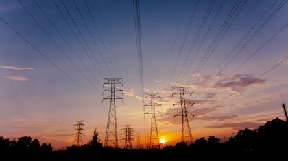 Electricity pylons standing tall against the evening sky, representing the strategic importance of grid resilience and capacity