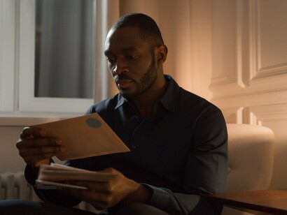 A man carefully handling a letter, representing the emotional connection preserved through letters