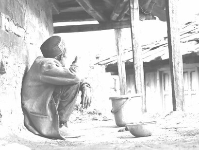 Poor man with a bucket and cup