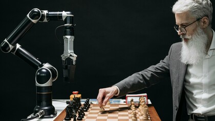 Un homme joue aux échecs avec une machine représentant une lutte entre l'intelligence humaine et l'intelligence artificielle