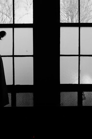 Two figures facing away beneath arched windows, symbolizing relational drift and the invisible space between partners