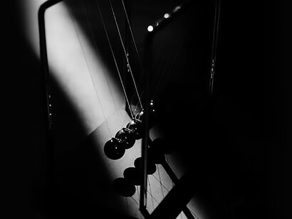 Newton's cradle showcases the conservation of momentum, as the collision between the swinging spheres transfers kinetic energy seamlessly down the line