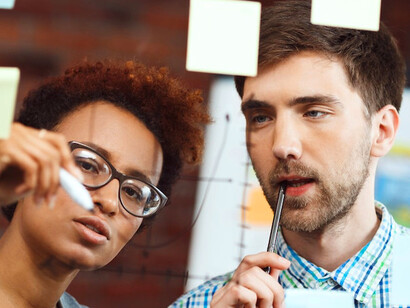 The two individuals use a creative approach, capturing all possible solutions on sticky notes, ensuring that no idea is overlooked in their brainstorming session
