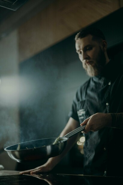 Uno chef che fa saltare in padella  delle verdure
