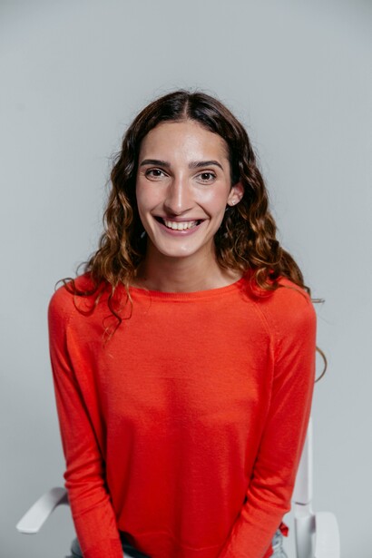 Ritratto a mezzo busto di una donna che sta sorridendo apertamente, con un'espressione radiosa e gli occhi che brillano