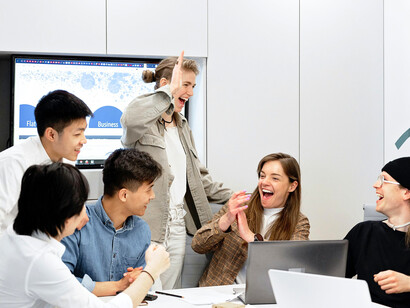 A collaborative team gathered around solutions, representing the power of humane and supportive workplaces