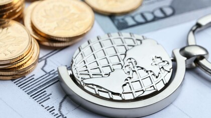 Monete, cartamoneta e mappamondo su sfondo bianco con grafici: "A partire dal 2008, infatti, le Banche Centrali introdussero tale nuova dottrina economica: avrebbero garantito immissioni “illimitate” (sono parole loro) di mezzi monetari a corso legale onde evitare le classiche crisi bancarie dovute a carenza di liquidi"