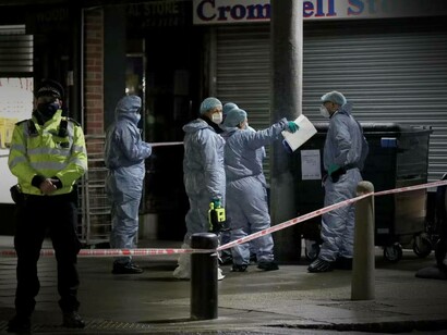 A police officer is guarding the crime scene as crime scene investigators work the case in London, England