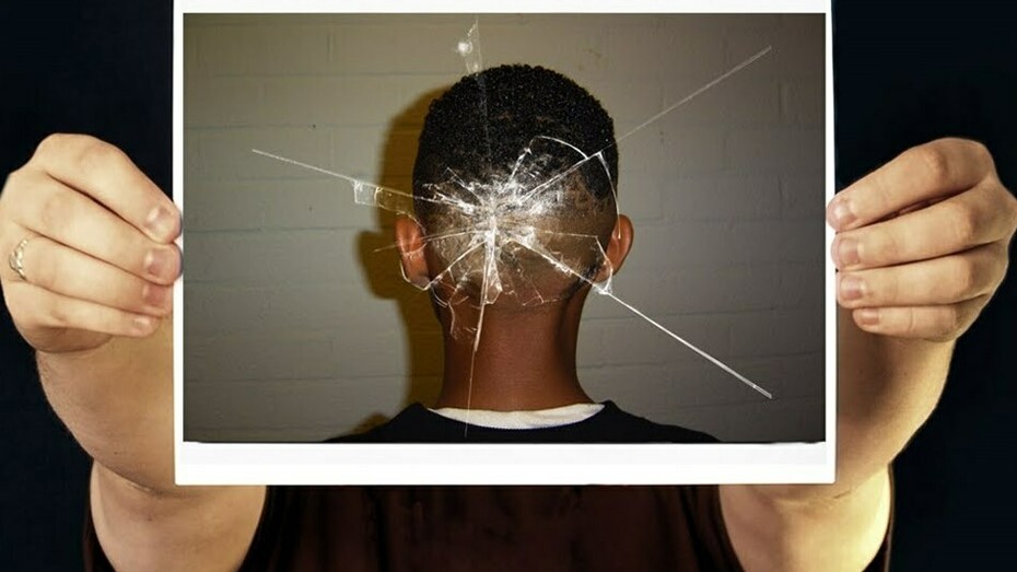 Fotografía de una cabeza con la marca de un cristal roto por un disparo