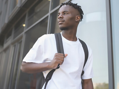 A photograph captures a young African American student engaged in school activities within a diverse classroom setting