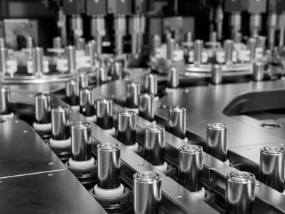 High-capacity lithium-ion battery cells are seen on a conveyor belt, highlighting the manufacturing process for high-voltage electric vehicle batteries