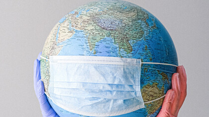 Um globo terrestre com máscara representando como o mundo ficou nos anos da pandemia de COVID-19