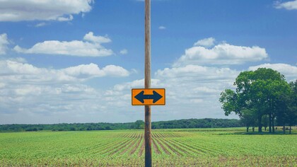 Placa indica caminhos opostos. Já ouviu aquele ditado “é tarde demais para mudar”? Pois é, vamos jogá-lo no lixo agora mesmo. Porque, sim, é possível e pode ser incrível reinventar-se profissionalmente depois dos 40