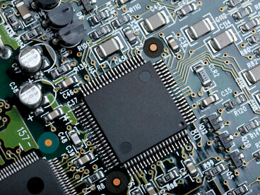 A high-performance microchip surrounded by electronic components, reflecting the growing importance of technological innovation in international relations