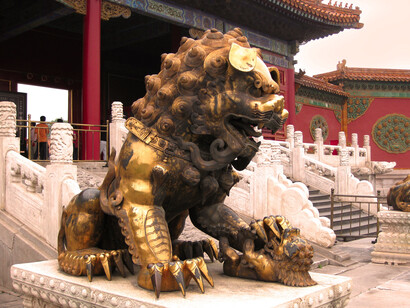 Un león guardián dorado frente al Palacio de la Longevidad Tranquila en la Ciudad Prohibida, Beijing, China