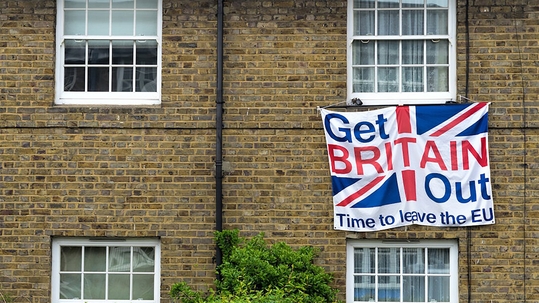 A brown brick building in the United Kingdom with a white fabric banner reading "Get Britain Out, Time to Leave the EU," reflecting the sentiment of the Brexit movemen