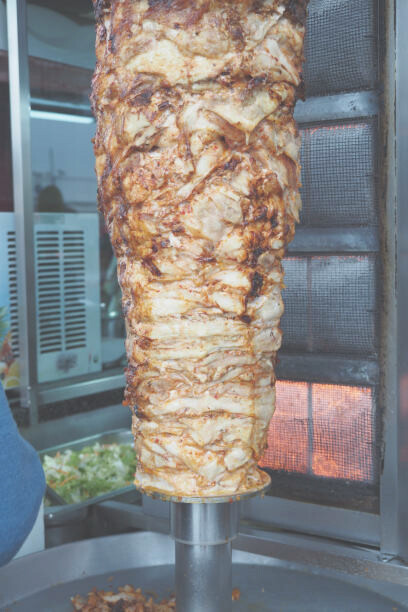 Doner kebab spit in a vibrant German street food restaurant, highlighting a beloved culinary tradition