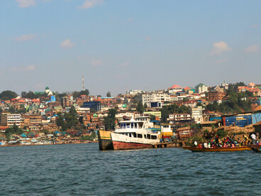 Boats going past the Bukavu city in Congo, representing the enduring impact of extractive economic systems.