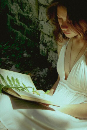 A person reading a book peacefully in a natural setting