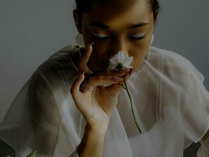 A woman smelling a flower and having a vision