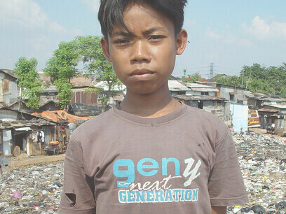 Un ragazzo che vive in una discarica di Cipinang Est, a Giacarta, in Indonesia. Immagine scattata da Jonathan McIntosh, 2004