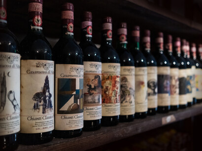 A row of bottles of Chianti Italian wines. It is easy to get a glass of inexpensive, excellent wine in Italy