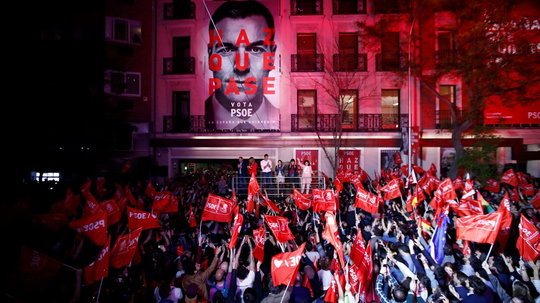 Simpatizantes del PSOE celebran la victoria en las elecciones delante de la sede del partido en la madrileña calle de Ferraz