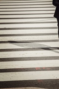 Homem cruza a rua na faixa de pedestres