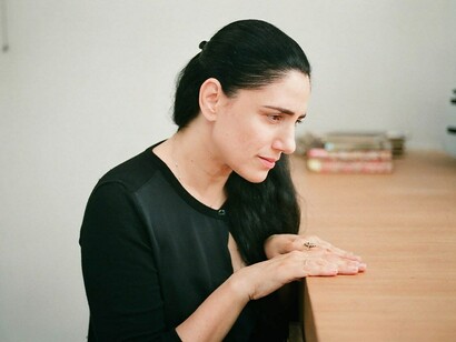 Una mujer mira sus manos desnudas