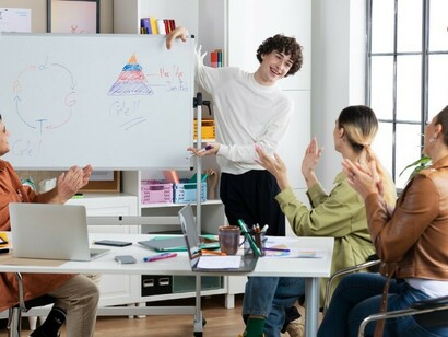 Students engage in a lively discussion while working on problems at a whiteboard