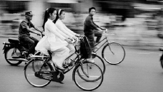 The morning commute, Young schoolgirls dressed in the traditional Ao Dai. Saigon, Vietnam, 1994