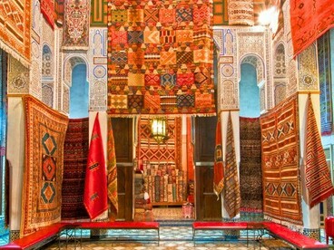 Moroccan rugs brightening historic Fez architecture, reflecting the city’s enduring cultural vibrancy