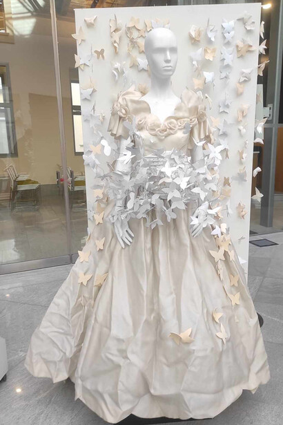 Un abito da sposa grigio e beige, al di sopra dell'abito e dello sfondo sono stati applicati degli ornamenti 