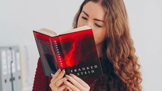 A woman enjoying her reading of a copy of Mary Shelly's novel Frankenstein