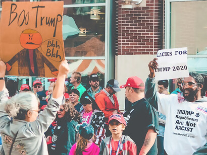 Group of individuals holding banner outside building in preparation for US elections