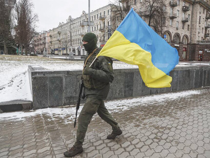 Soldado del Ejército marcha con una bandera de Ucrania