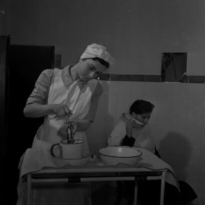 Practicante de enfermería Joyce Collier irriga el oído de un niño en el Departamento de Consultas Externas del Hospital St Helier. 1943