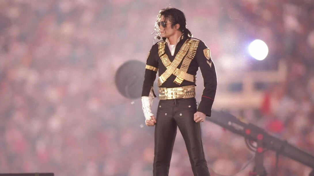 Michael Jackson posa com um dos figurinos mais emblemáticos de sua carreira, marcado por detalhes militares, fivelas e brilho. Na era Dangerous, o artista ampliou o uso da moda como ferramenta de expressão visual. O visual ajudou a consolidar uma das identidades estéticas mais reconhecidas da música pop