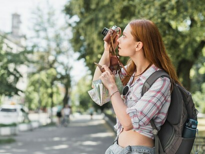 A woman standing in a park with a map, embarking on a new chapter of love migration and cultural adaptation in a foreign land