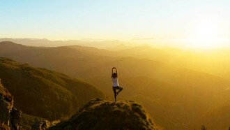 A meditation enthusiast doing yoga on a cliff and enjoying the spiritual freedom and physical strength it brings