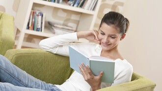 Una chica leyendo un libro en casa