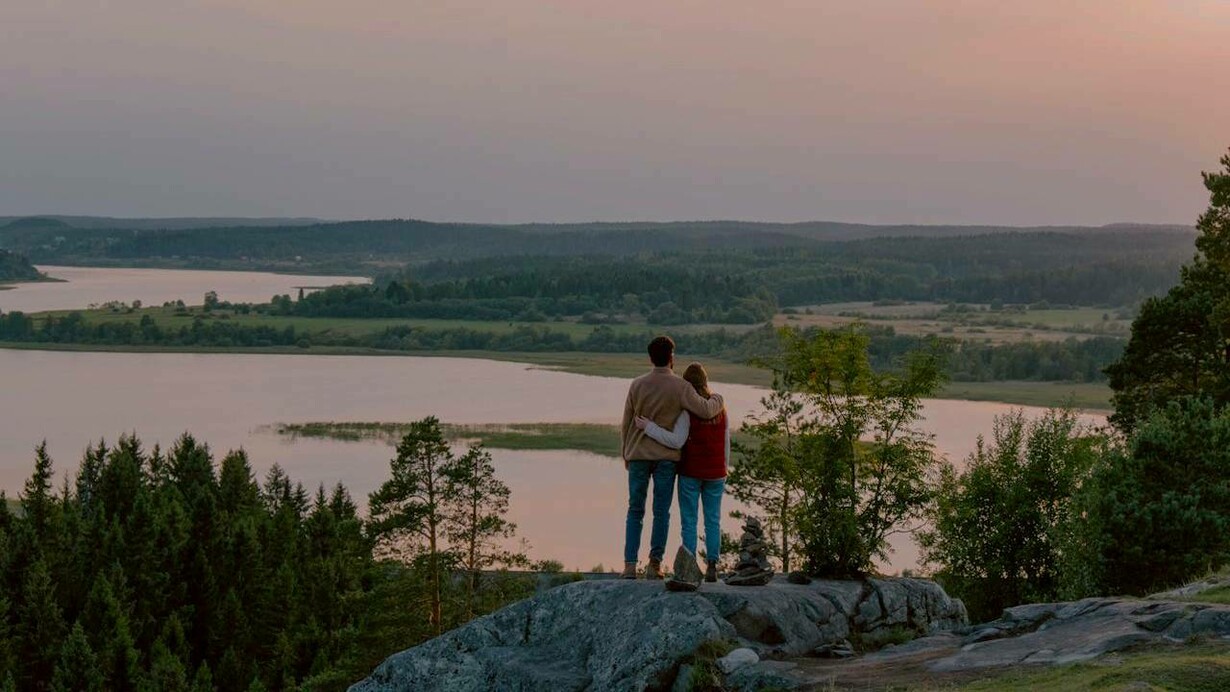 Uomo e donna abbracciati di fronte a un paesaggio naturale: “La natura non è solo un luogo da esplorare, ma una vera e propria terapia per il corpo e la mente”