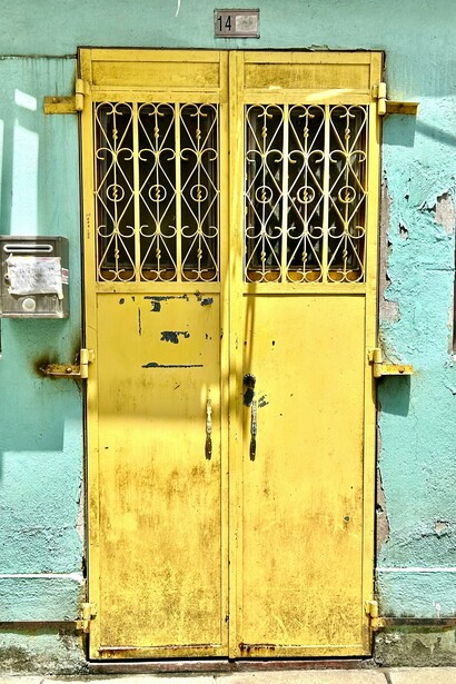Yellow door with decorative grill ornaments in Taipa, Macau ©Alma Reyes