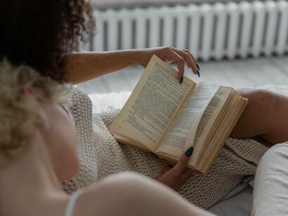 A couple having a relaxing time reading a novel together in the modern age