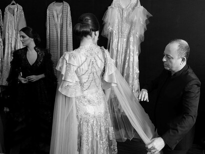 Fashion designer Albert Oiknine making sure the caftan design on his model fits perfectly