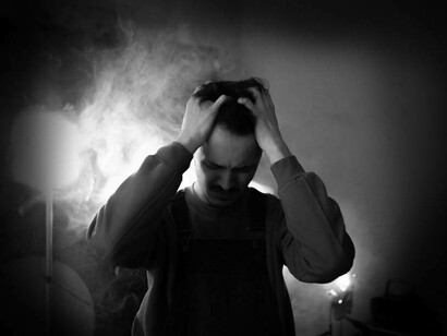 Persona che manifesta la sua frustrazione con il viso contrito e le mani tra i capelli
