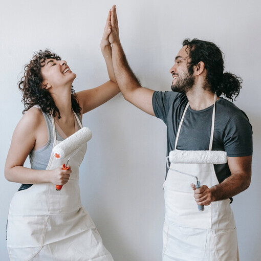 Amigos se divertem ao finalizar projeto de pintura