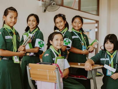 A group of students in green uniforms, showing diversity